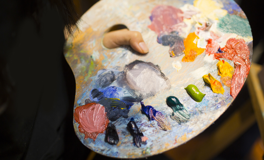 A hand holding a paint colour palette