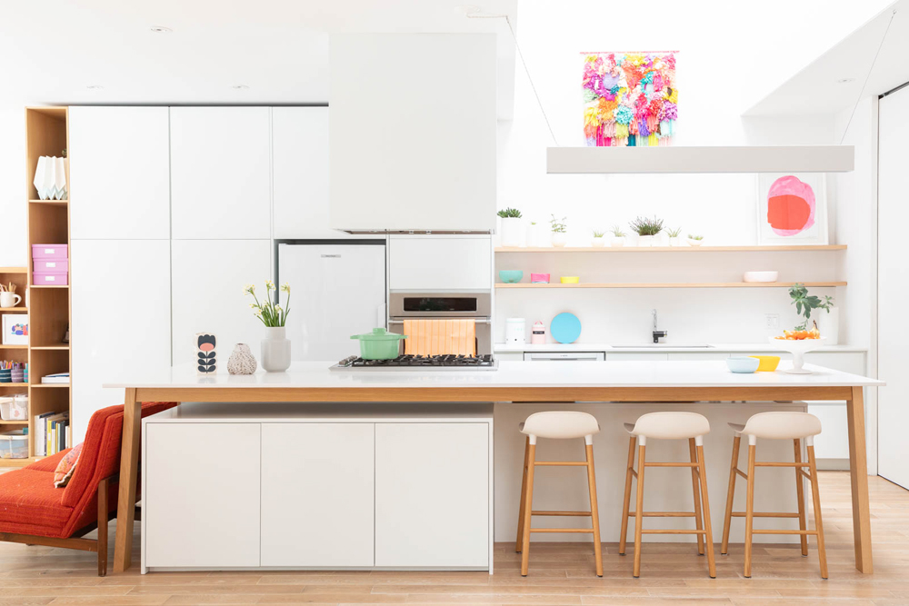 Recently renovated white kitchen with marble island and pops of colour and decor