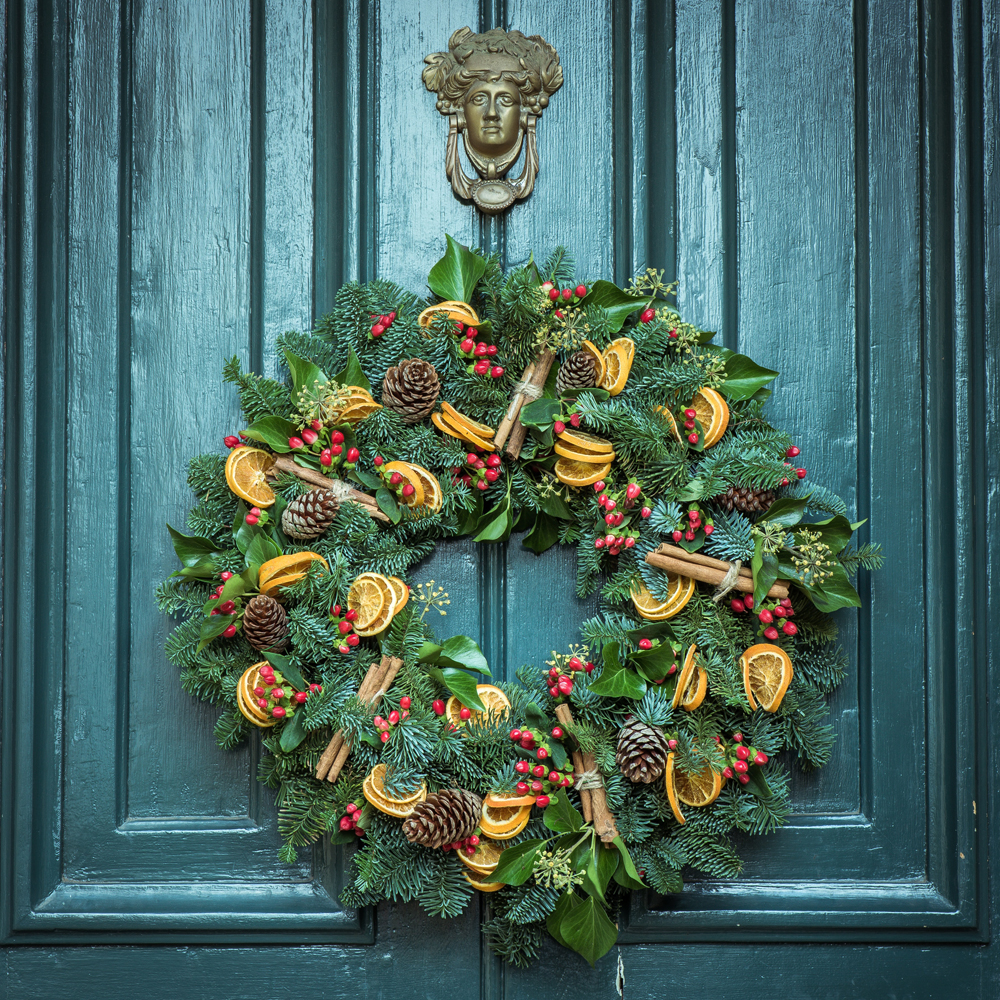 A homemade holiday wreath on the front door of a house