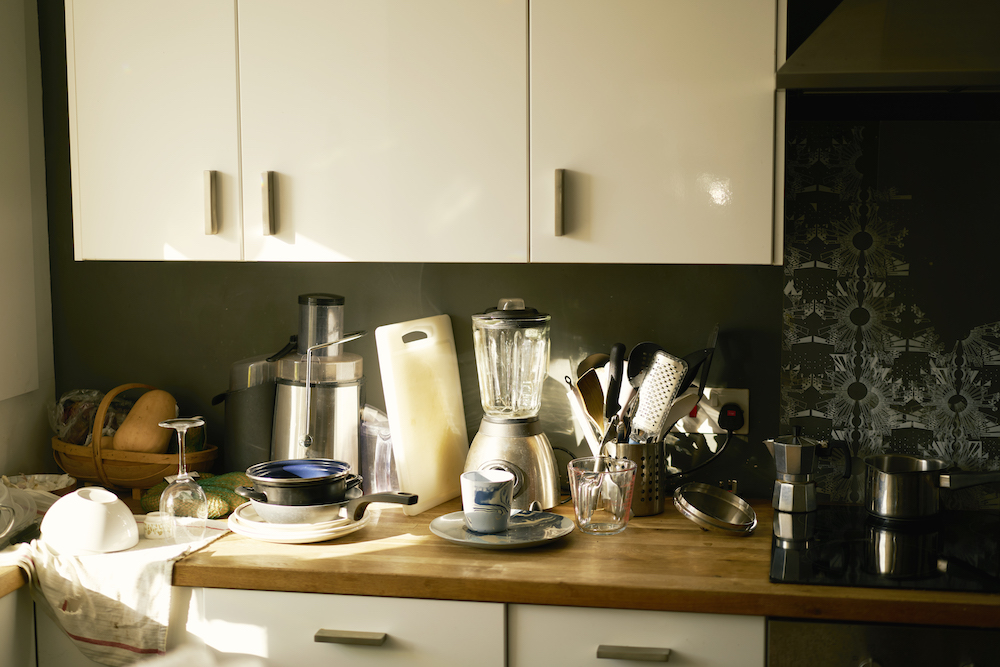 kitchen counter cluttered with dishes and small appliances