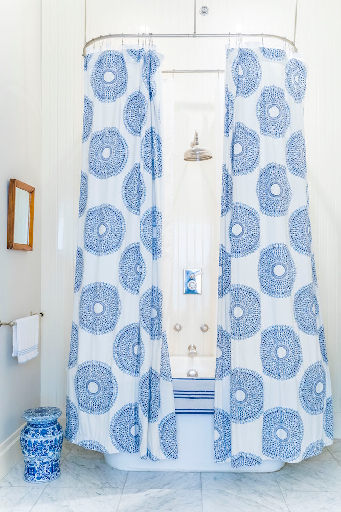 white bathroom with blue shower curtain