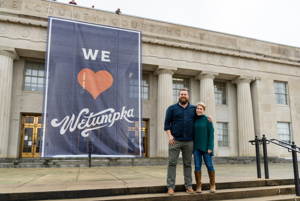 Home Town Takeover Ben and Erin Napier in front of Wetumpka sign