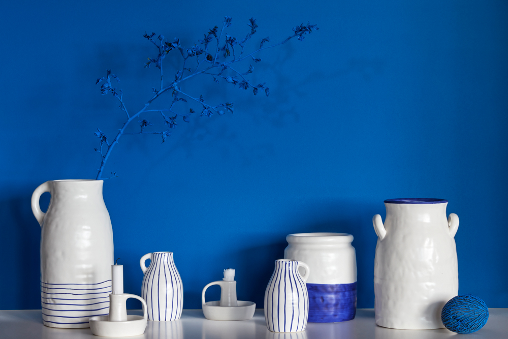 White and blue ceramic vases against a painted blue wall