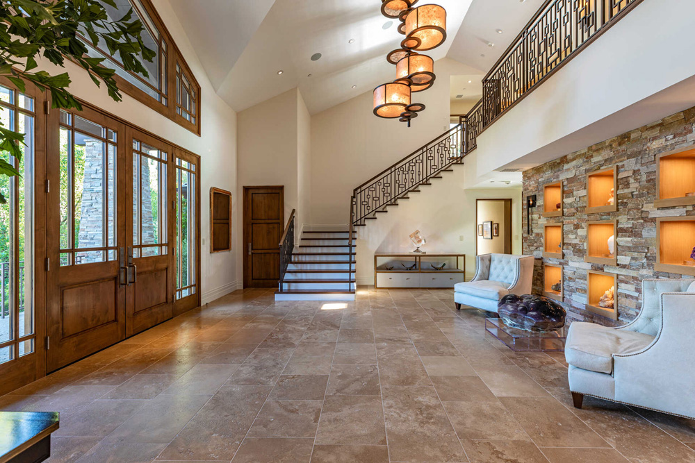 Front foyer with a winding staircase, unique light fixtures and wall units with knick knacks