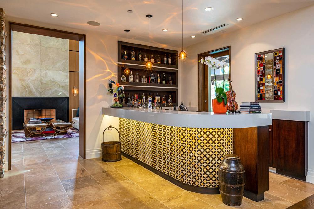 A bar off to the side of the living room with a light-up countertop