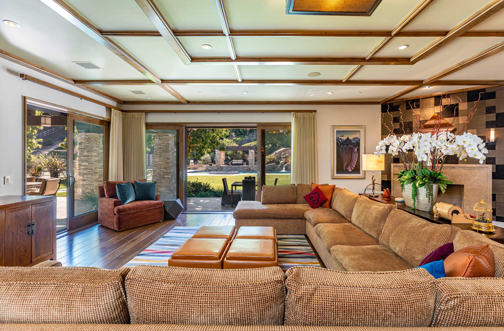 A wrap-around couch in a second family room that looks out onto the backyard