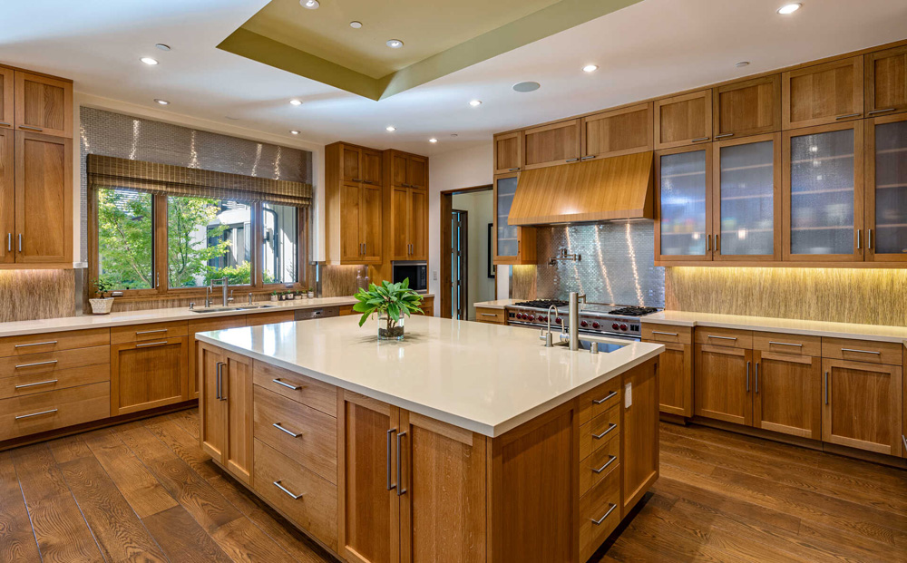 A spacious kitchen with blond wood flooring and cabinetry