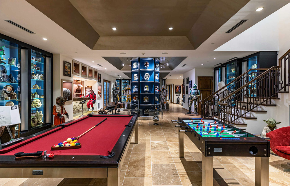 A games room with a billiard table and fooseball surrounded by Star Wars memorabilia
