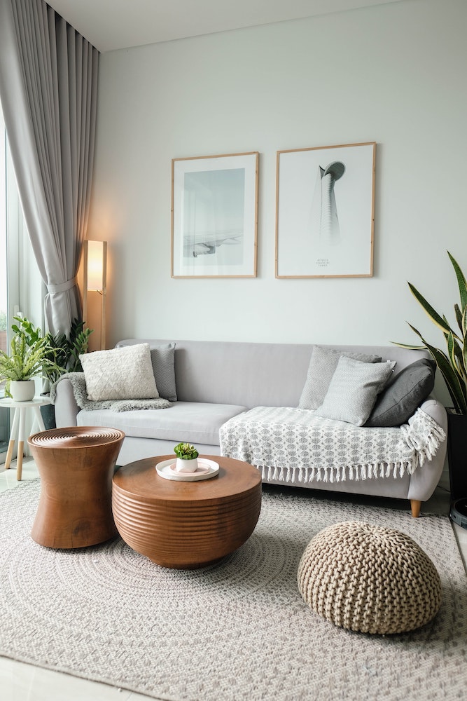 neutral grey living room with grey pillows on couch and sculptural coffee tables