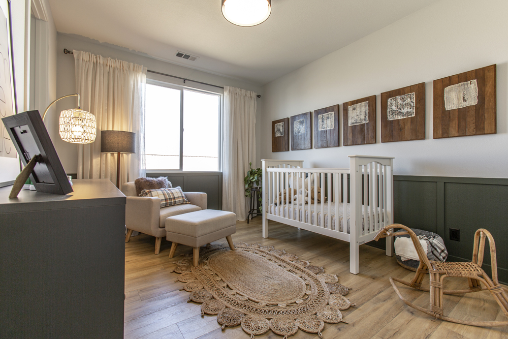 A neutral baby nursery with a unique wicker rocking horse and recycled wood picture frames