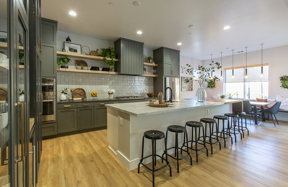A spacious open-concept kitchen with green cabinetry and a Dolomite marble island