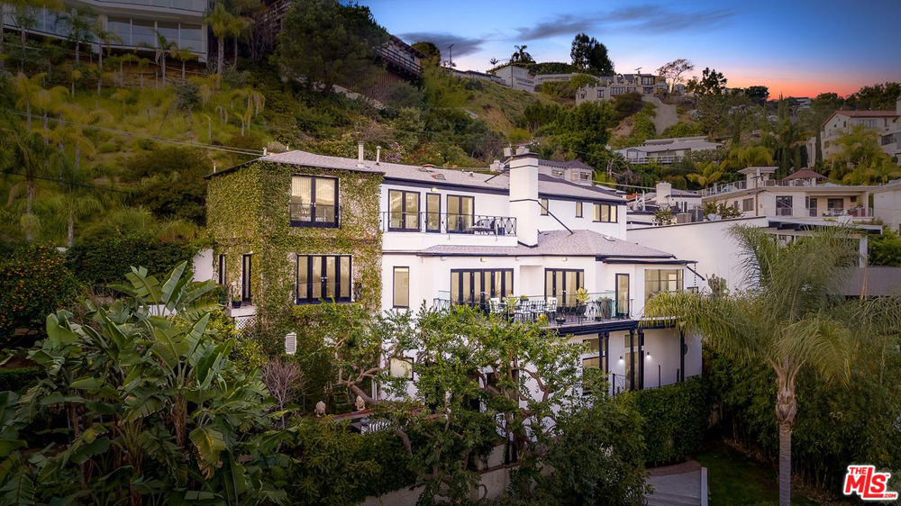 An exterior shot of the former Hollywood Hills mansion that once belonged to Judy Garland, surrounded by trees