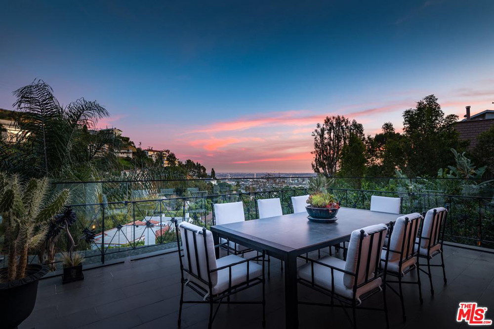 A dining table on the balcony overlooking the Hollywood Hills at dusk