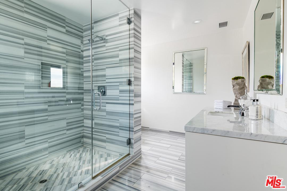 A guest bathroom with a large standing walk-in shower and separate vanity