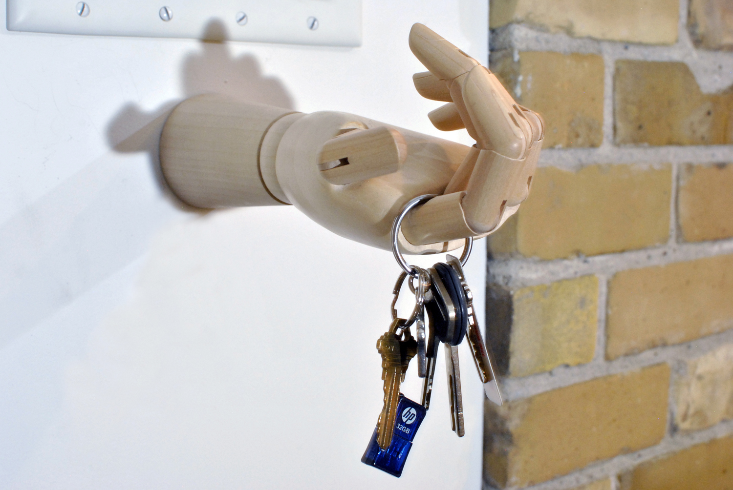 A hand keyholder attached the wall of the entryway to the basement apartment