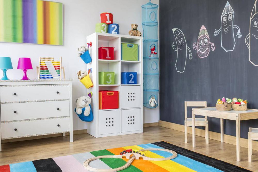 A bright and bold kids' playroom with a full chalkboard wall