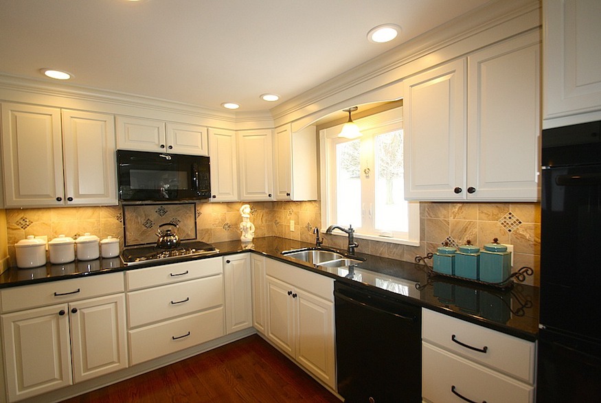 Traditional kitchen with white cabinetry and black countertops