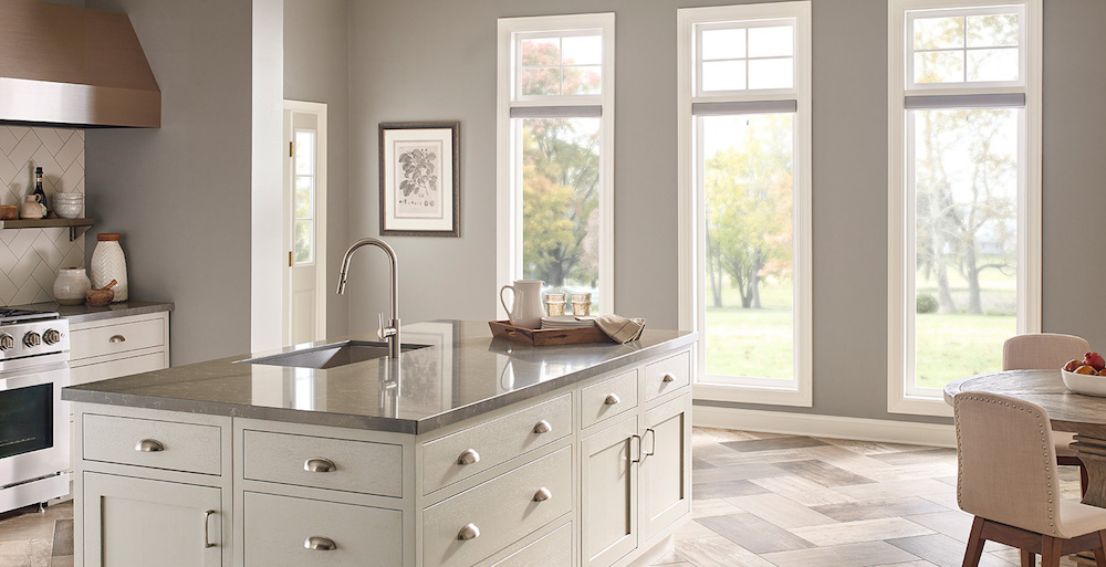 light-filled grey kitchen with three windows and a large centre island