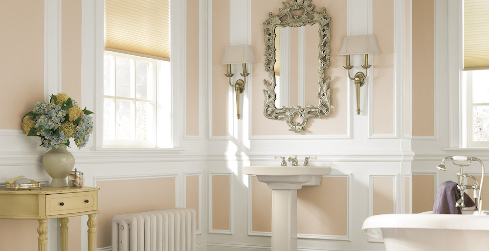 classic bathroom with peach-and-white walls and an ornate silver-frame mirror