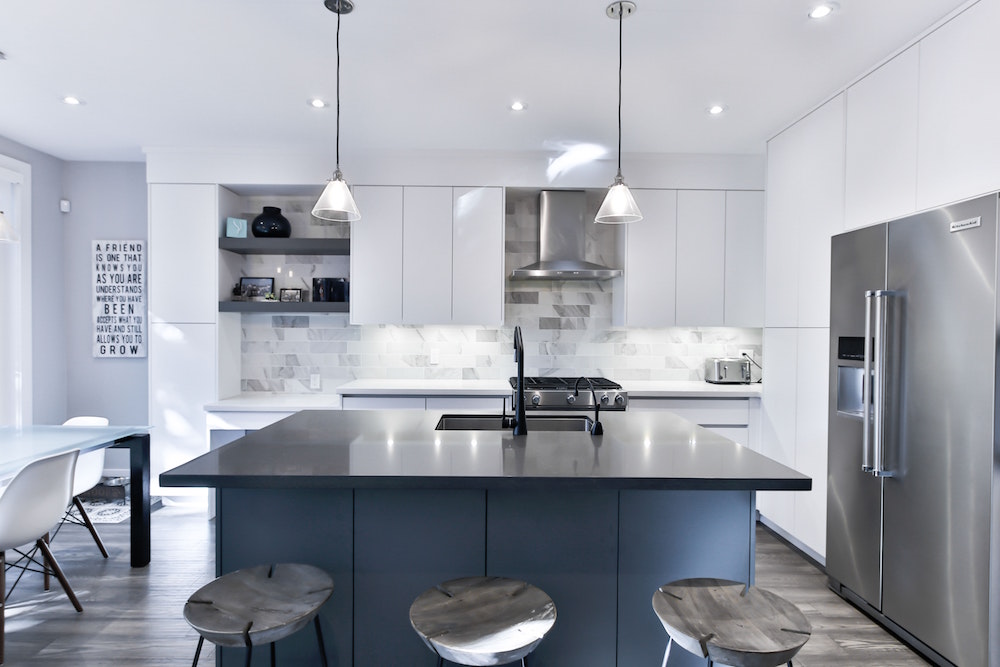 modern white kitchen with white cabinets and navy island