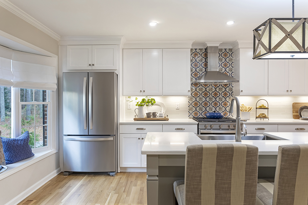 white kitchen with mixed cabinet hardware and patterned backsplash detail