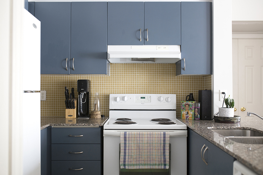 kitchen with yellow backsplash and blue cabinets