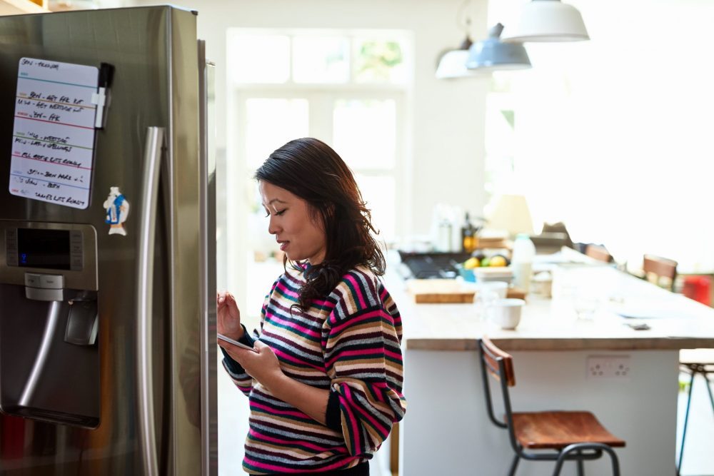 woman checking food in stainless steel fridge