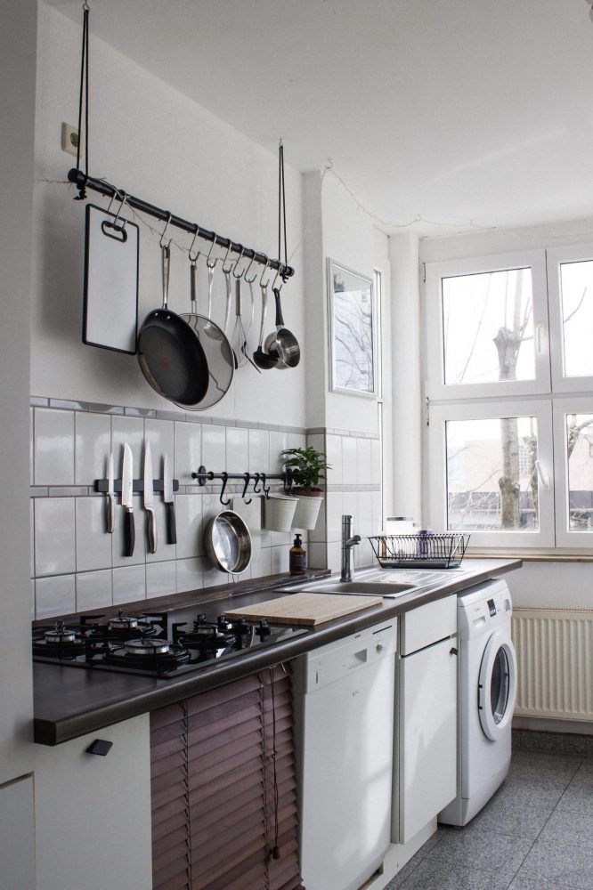 white kitchen with hanging knives and pans