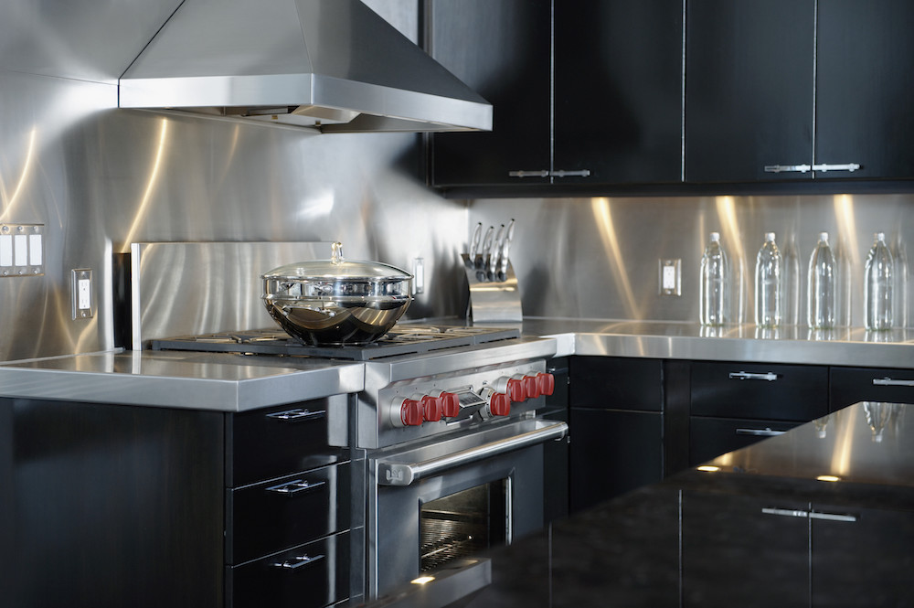 upscale kitchen with stainless steel counter and black cabinets
