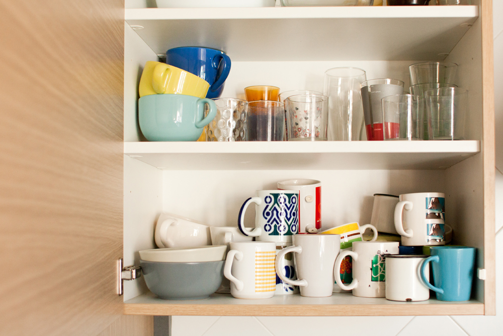 A cupboard with old novelty mugs that need to be replaced