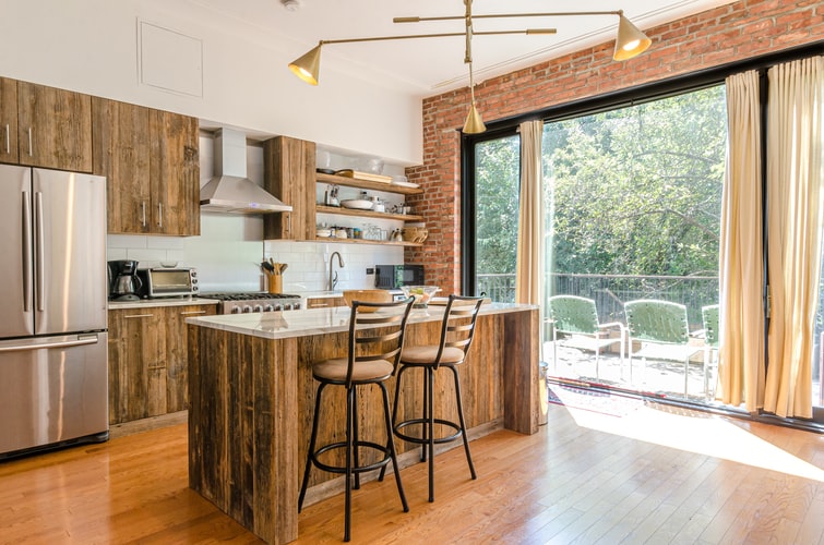 Kitchen with wooden cabinets, brick wall and stainless appliances