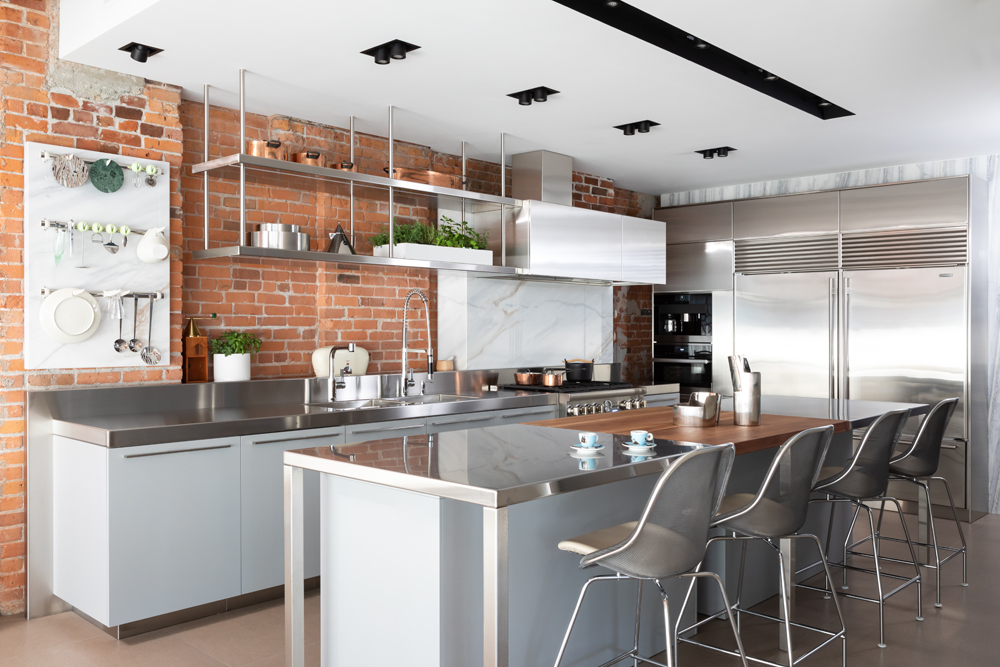 modern kitchen with wood and metal cabinets, marble backsplash and brick walls