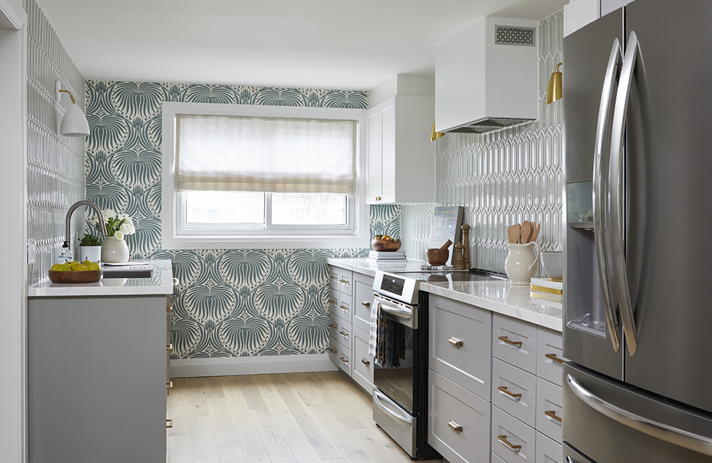 grey kitchen with bold patterned wallpaper on one wall