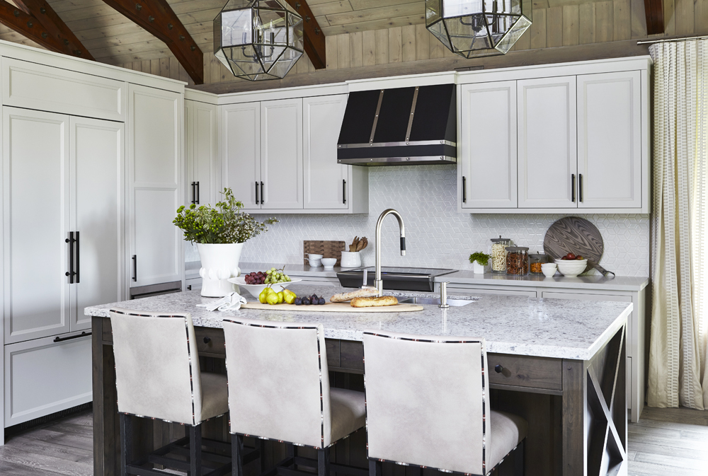 A rustic kitchen with white marble island and wood beam ceilings