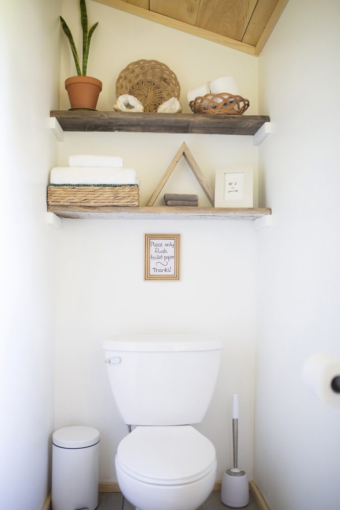 white bathroom with wooden shelves