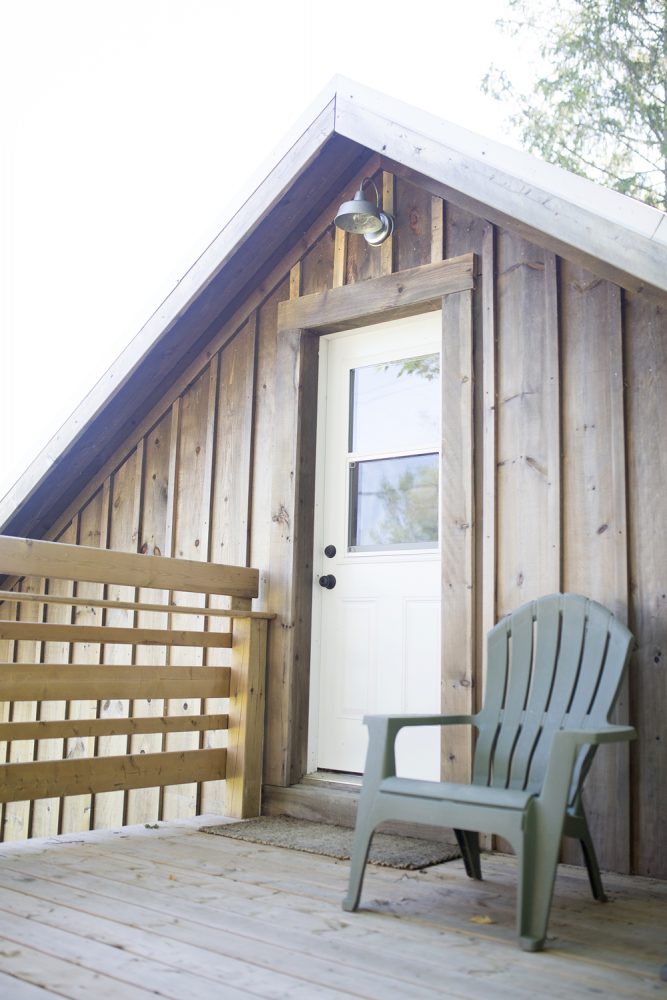 green chair in front of wooden barn exterior