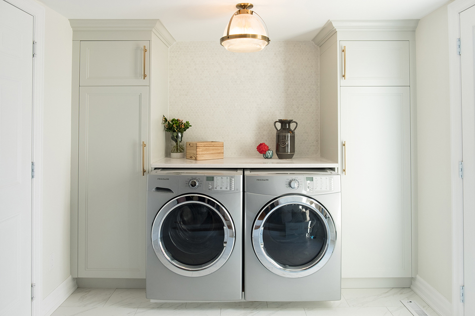 Small laundry space with floor-to-ceiling cabinets and a folding surface.