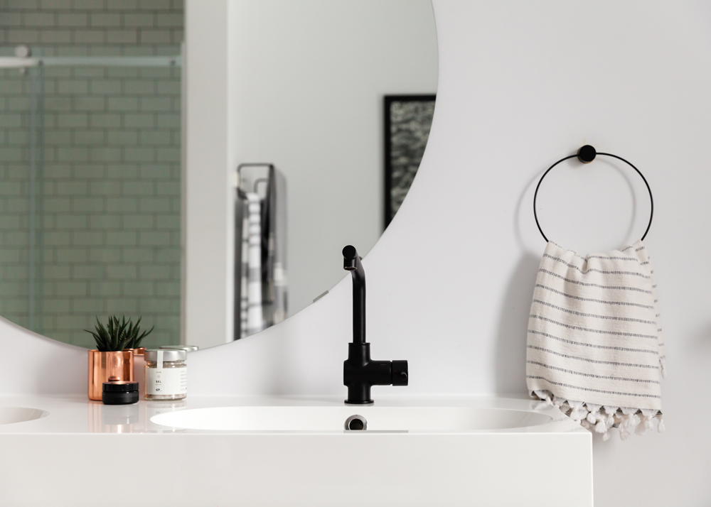 bathroom round mirror, black faucet, copper planter