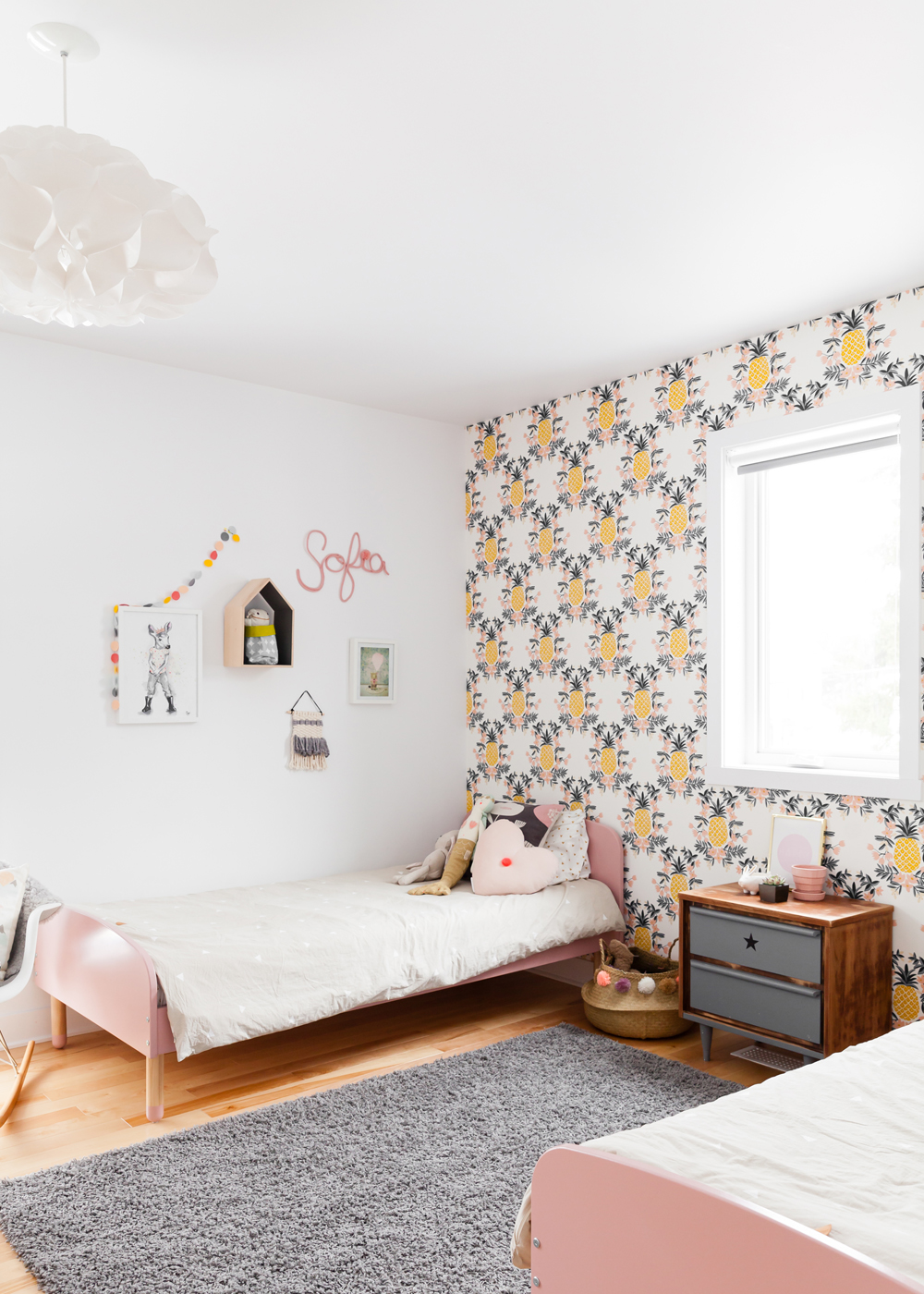kids room with pink twin beds and pineapple wallpaper