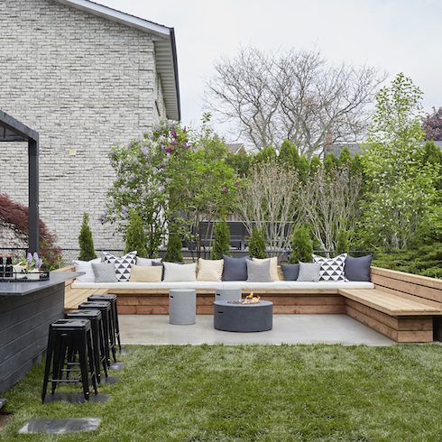 backyard with black deck and wooden bench seating area