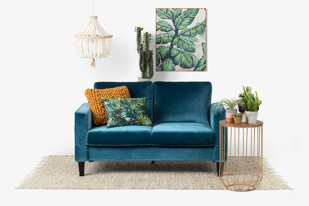 Blue velvet loveseat in boho-styled living room