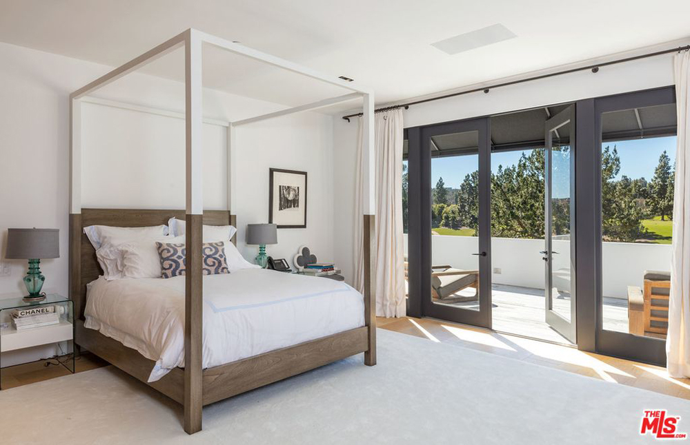 A spacious bedroom with French doors leading onto a private balcony
