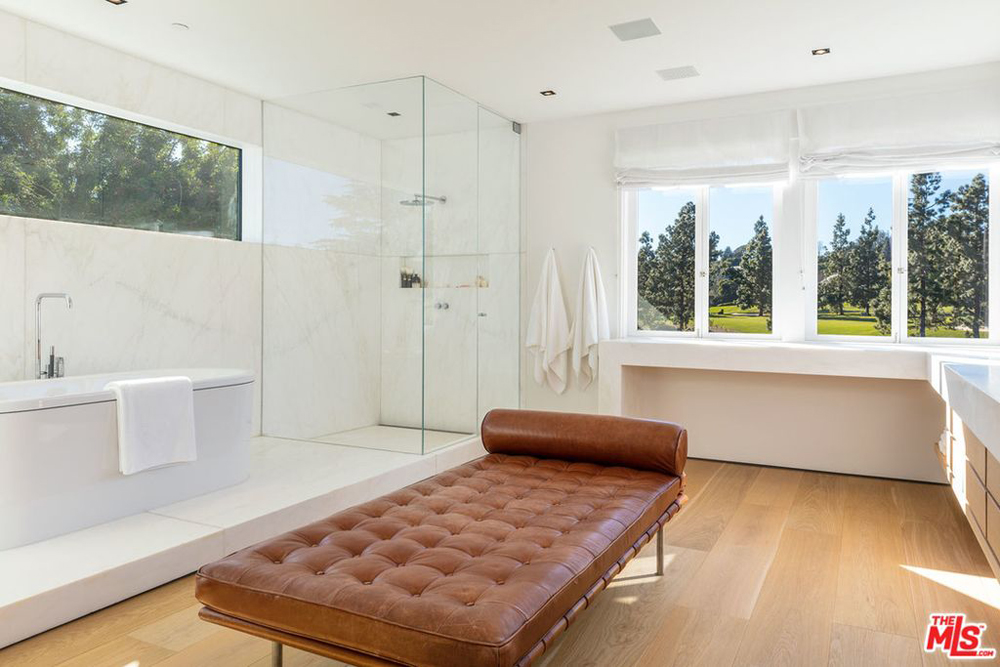 A spacious spa-like master bathroom with a chaise lounge, standing shower and separate bath tub