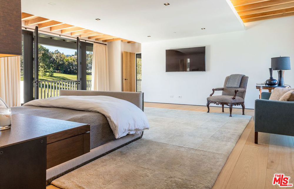 Master bedroom with a private balcony and a door leading into the ensuite bathroom