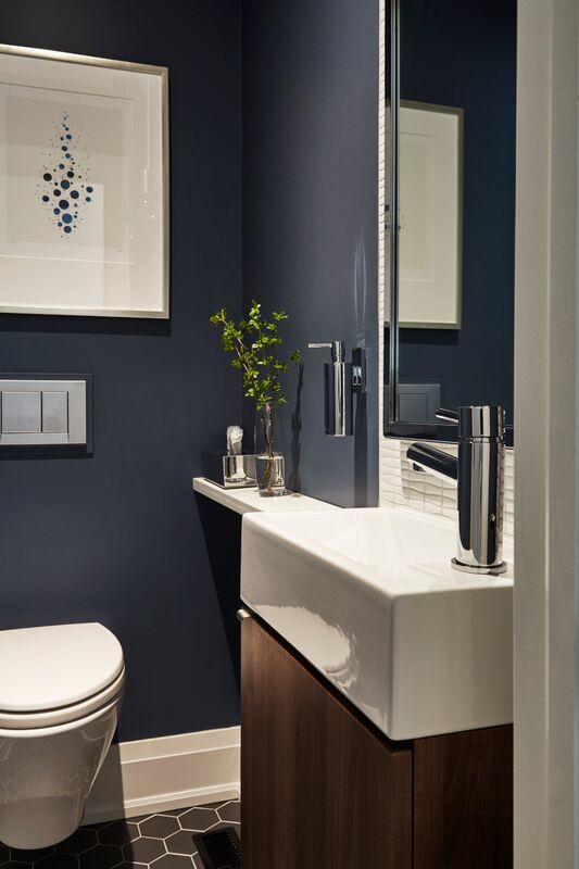 blue powder room with white floating toilets and narrow white shelf beside white sink vanity