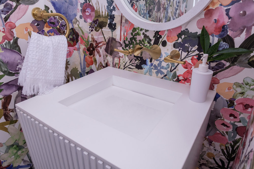 Powder room with floral wallpaper and white sink
