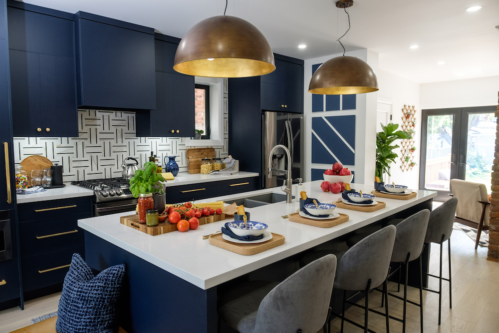 Blue and white kitchen with gold pendant lights over kitchen island