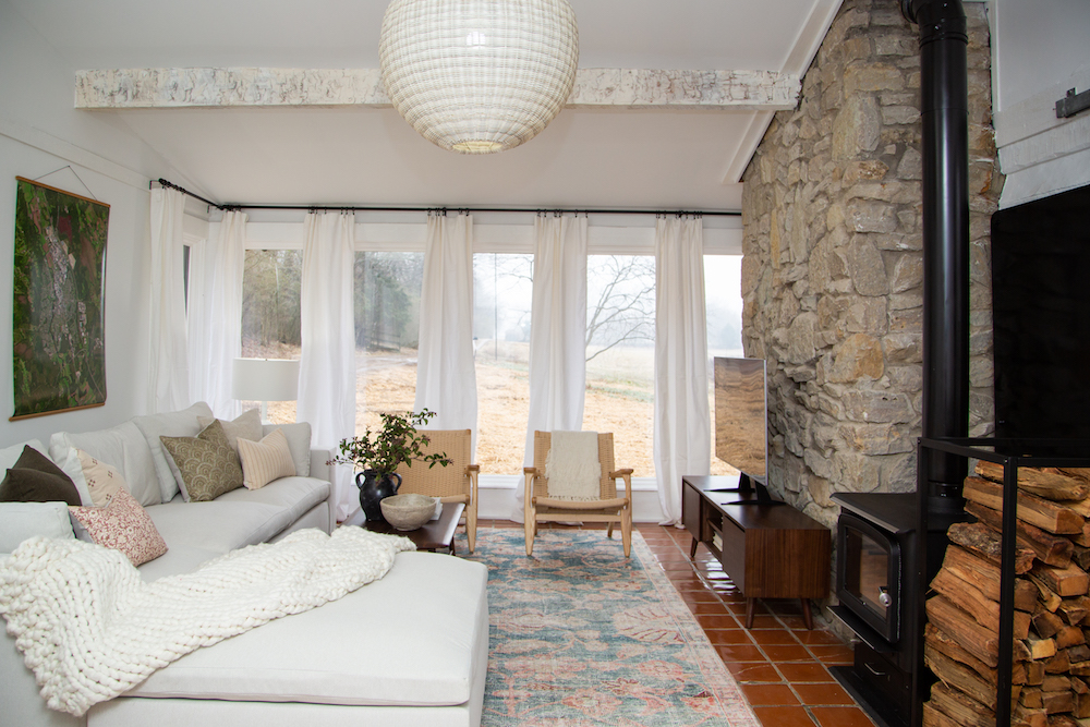 Renovated living room with stone wall and fireplace