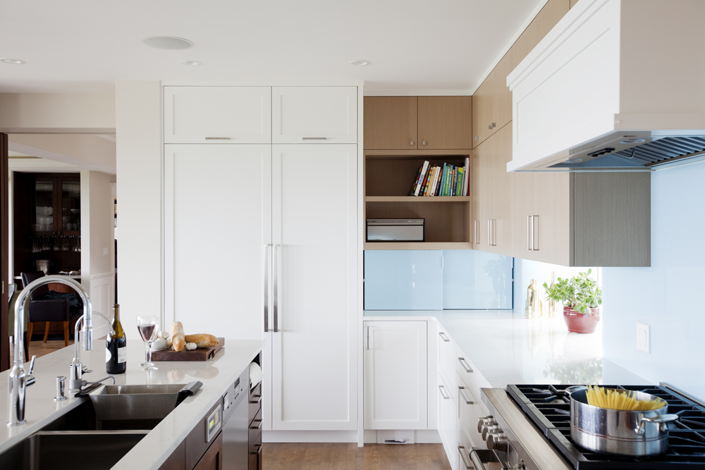 A tidy kitchen with plenty of cupboard space and a pot of pasta boiling on the gas stove
