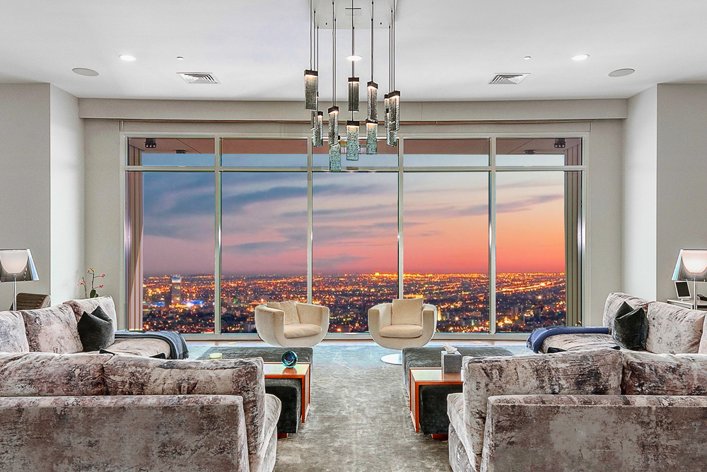The Los Angeles city views from the floor-to-ceiling windows in front of the living room seating area